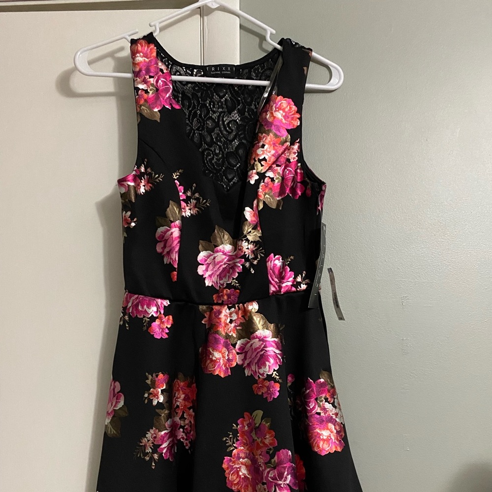 Black little dress with flower detailing. Silky material with lace back